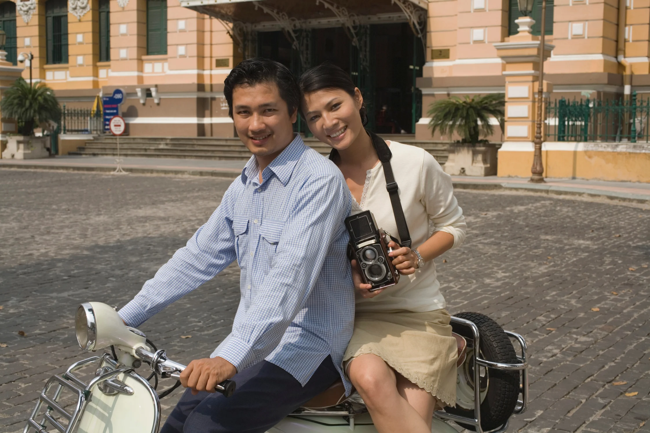 Couple on a scooter outside a landmark building